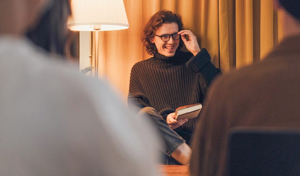 Author doing a book reading at a cozy coffee shop