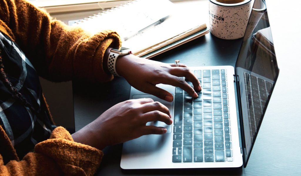 Someone typing on a laptop, writing a story