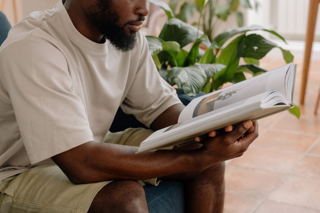 Person holding a Blurb photo book in front of a plant